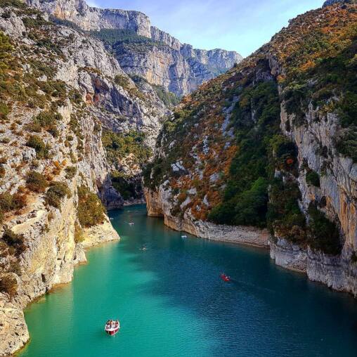 Sheer limestone walls dropping to the turquoise Verdon river, small boats and canoes scattered across the water far below