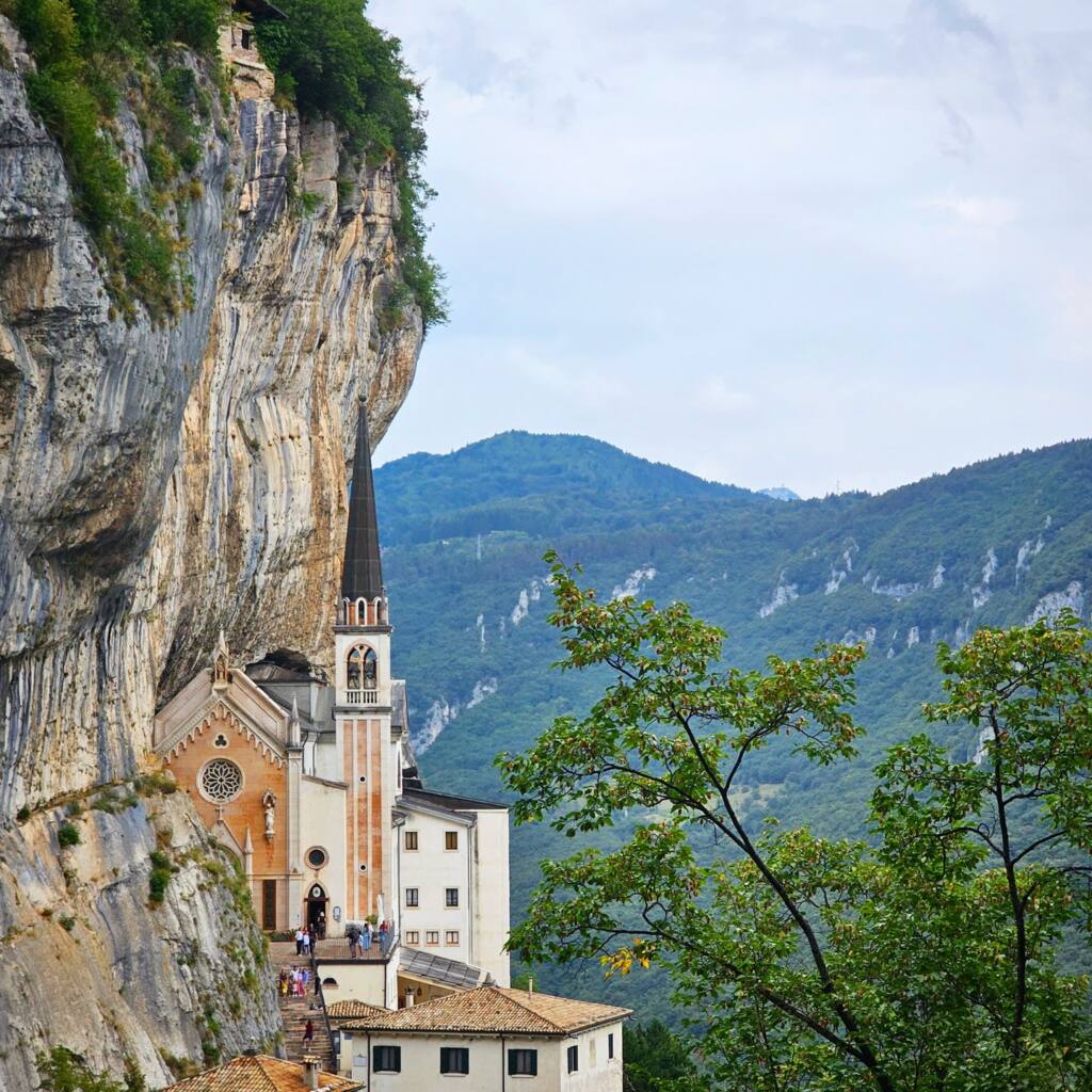 Church built into a vertical cliff face high above a wooded valley