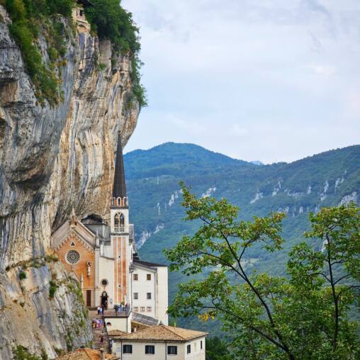 Church built into a vertical cliff face high above a wooded valley