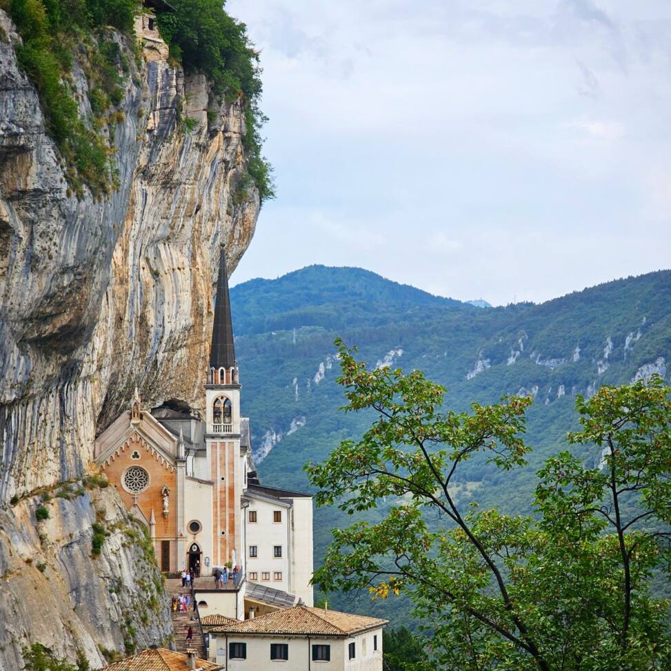 Church built into a vertical cliff face high above a wooded valley